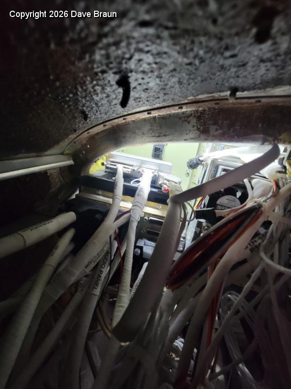 2024-10-20 18.37.34.jpg - Peering through the battery close out panel. Relocating the battery is almost a requirement for installing this type of panel.
