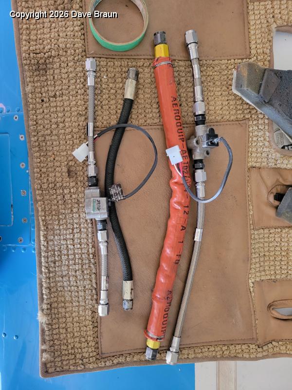 2024-02-22 16.44.18.jpg - The old fuel lines with the replacement lines and the transducers. The transducers greatly reduced the bend radius of the lines, and if doing this again I would play with some elbows and perhaps shorter lines.